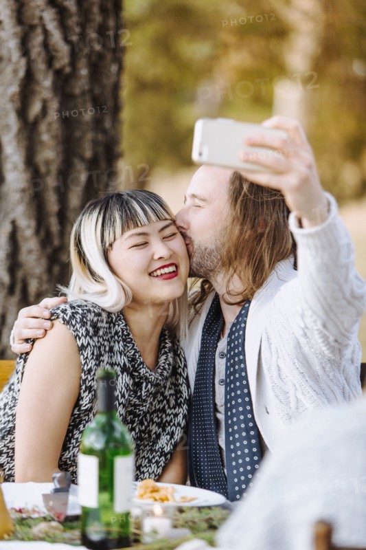 Couple taking selfie at outdoor table