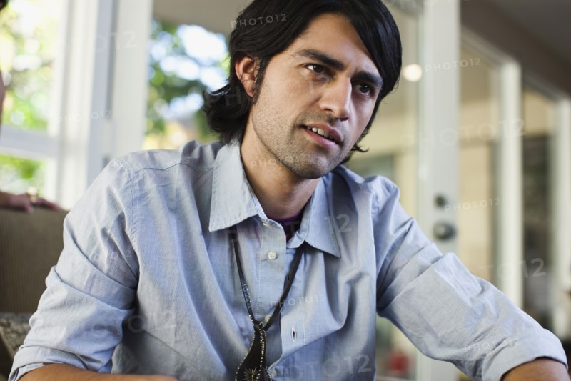 Hispanic man sitting indoors