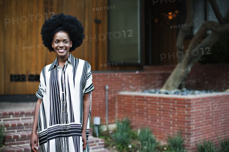 African American woman standing outside house