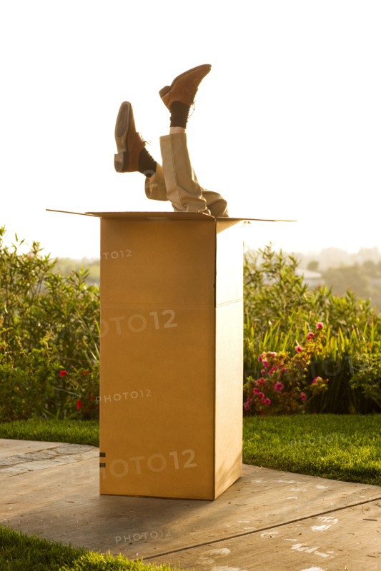 Man upside-down in cardboard box