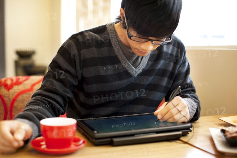 Mixed race man writing on digital tablet