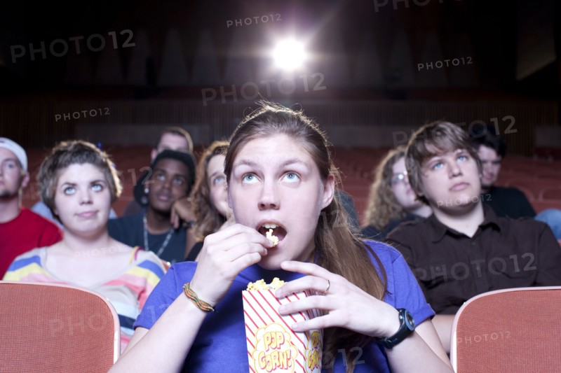Caucasian woman eating popcorn in movie theater