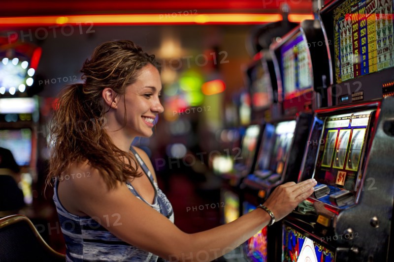 Caucasian woman playing slot machine in casino