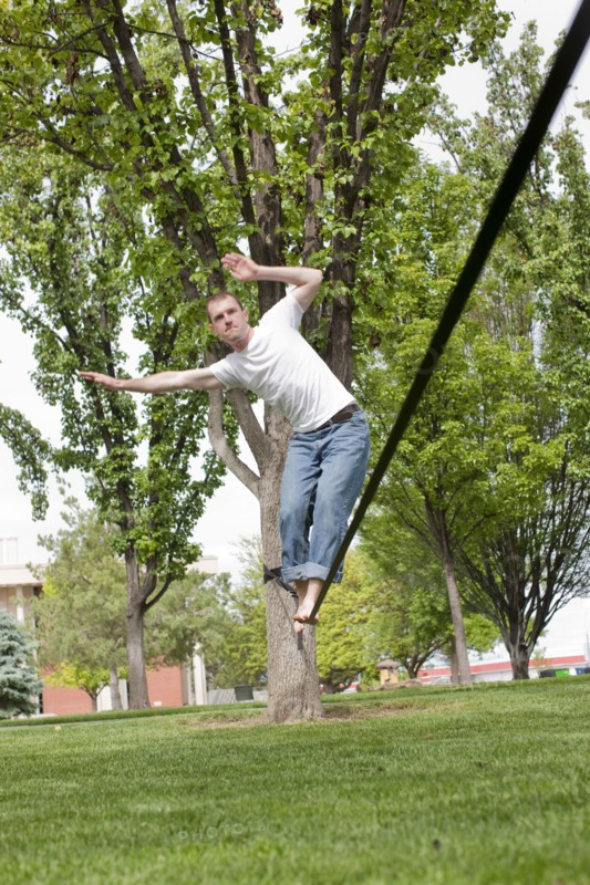 Caucasian man balancing on rope in park