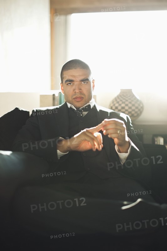 Serious mixed race businessman sitting in chair
