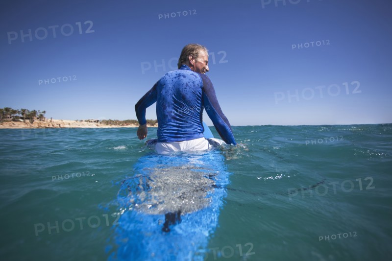 Caucasian man floating on surfboard