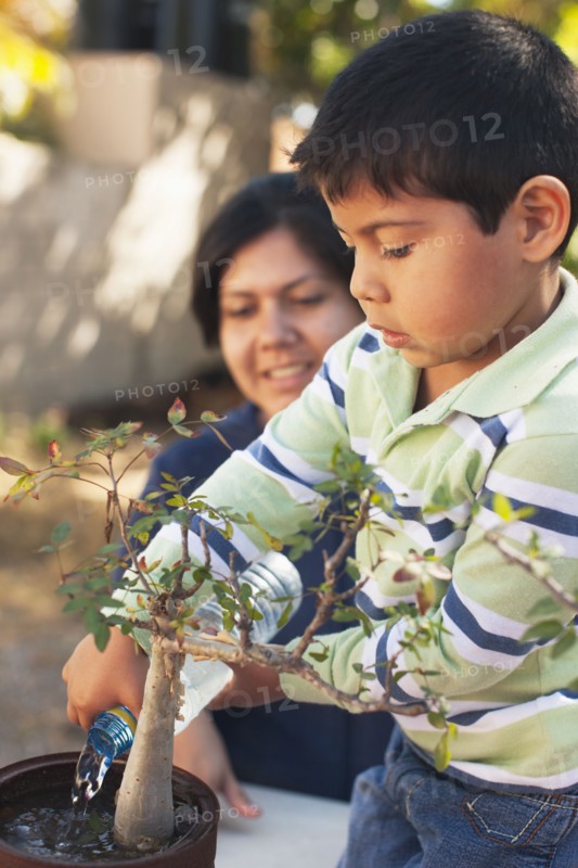 Hispanic mother and son gardening together
