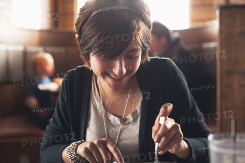 Caucasian teenager eating in restaurant