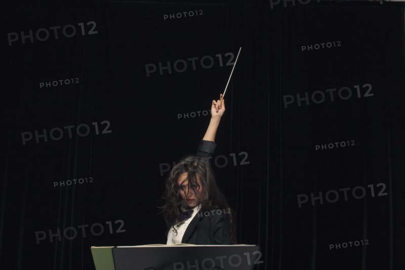 Mixed race conductor pointing baton
