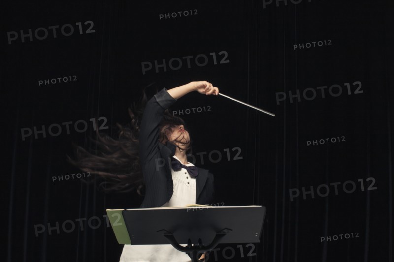 Mixed race conductor pointing baton