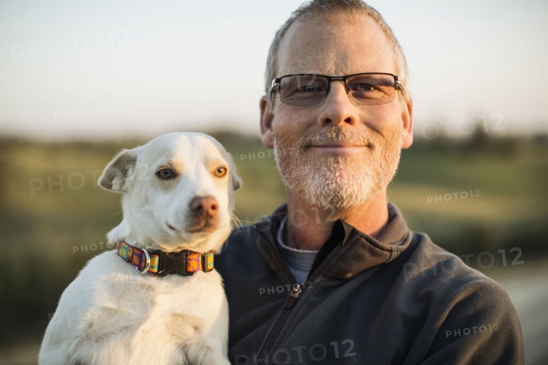 Caucasian man holding dog outdoors