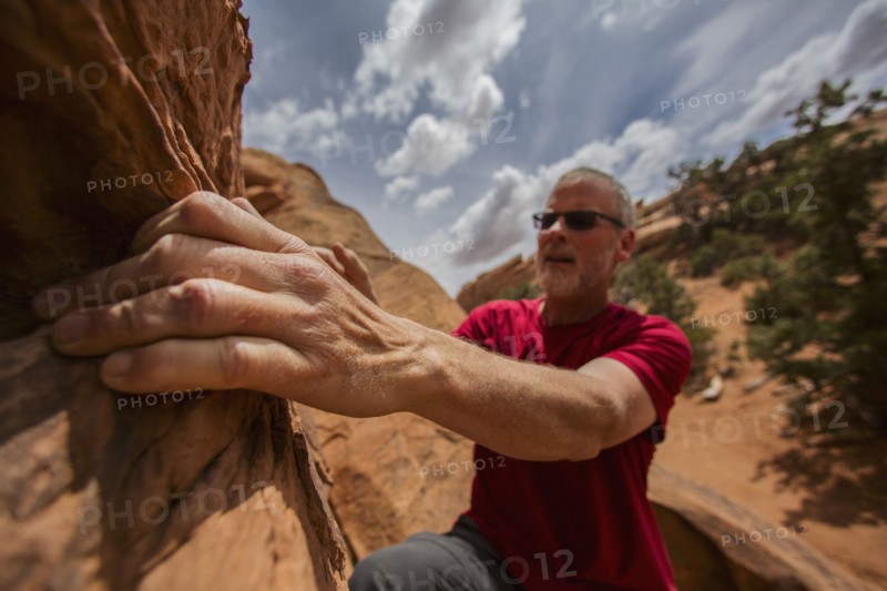 Caucasian rock climber scaling cliff