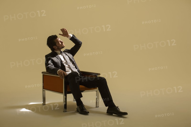 Caucasian businessman sitting under spotlight