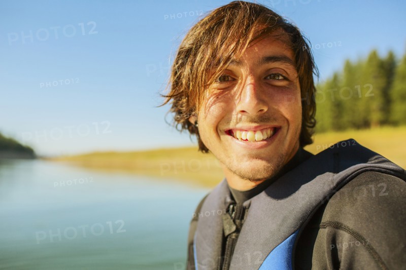 Caucasian man smiling by rural lake