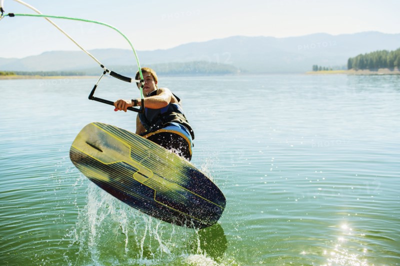 Caucasian man wakeboarding on lake