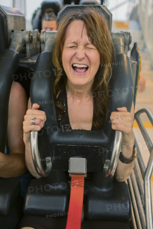 Caucasian woman shouting on roller coaster