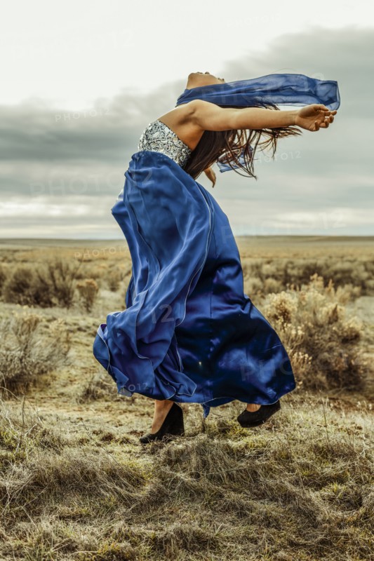 Chinese teenage girl playing with scarf in rural field