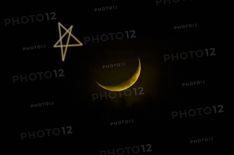 Star drawn by crescent moon in night sky