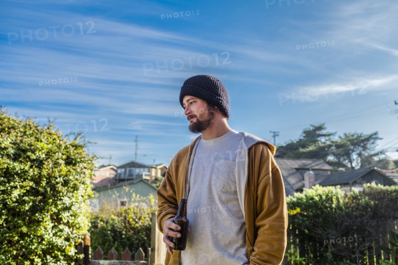Caucasian man drinking beer in backyard