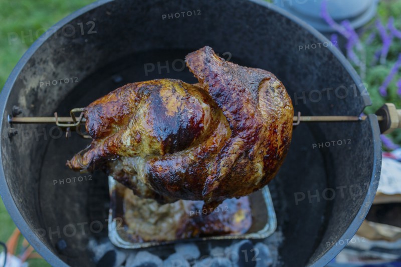 Close up of chicken cooking on rotisserie barbecue