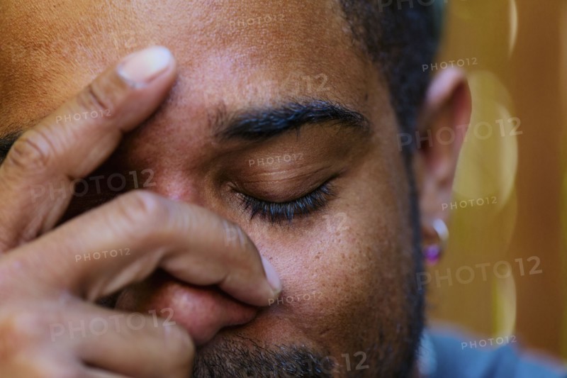 Close up of mixed race man holding head in hands