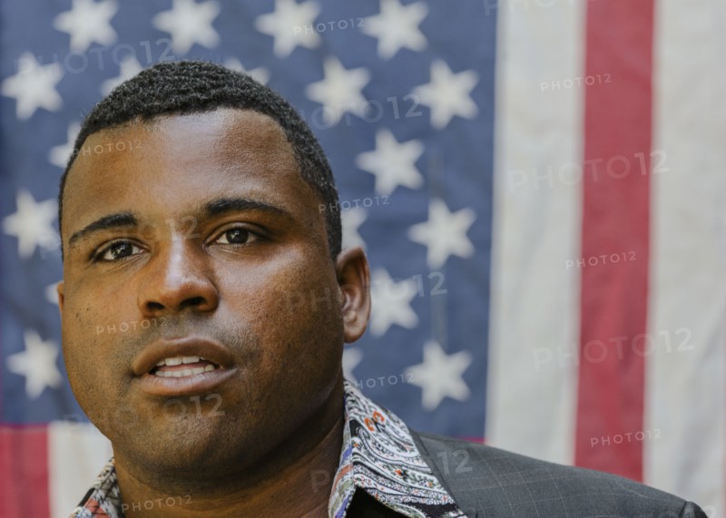Close up of Black man in front of American flag