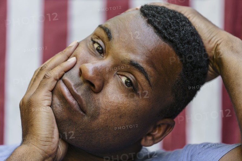 Close up of concerned Black man  in front of American flag
