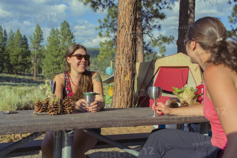 Caucasian women drinking wine at campsite