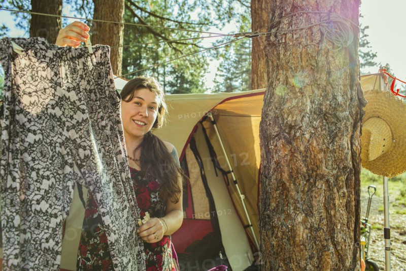 Caucasian woman hanging laundry at campsite