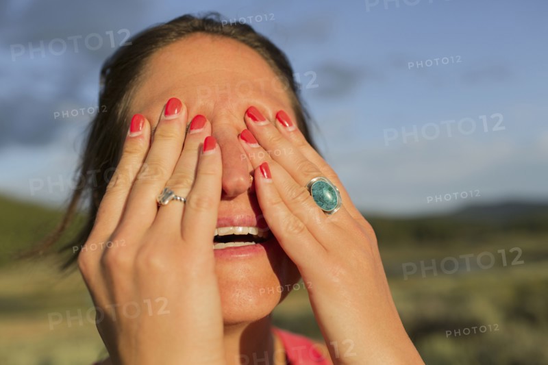 Close up of Caucasian woman covering her eyes