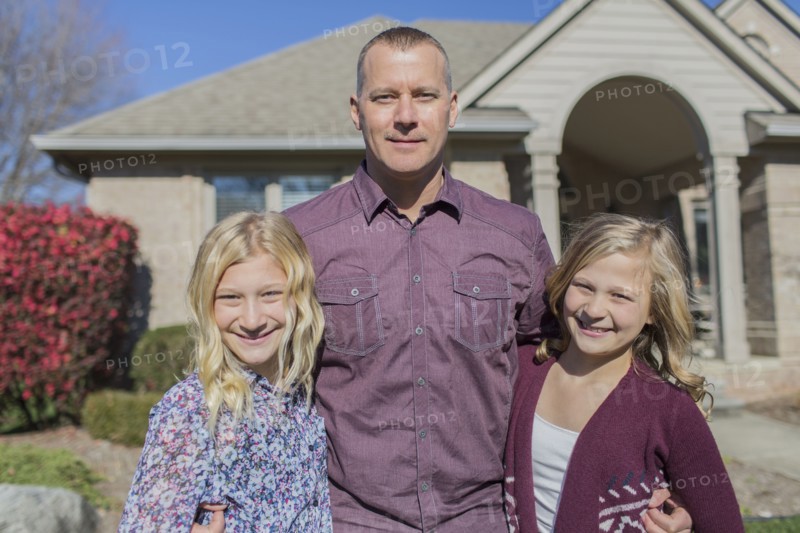 Caucasian father and daughters smiling in yard