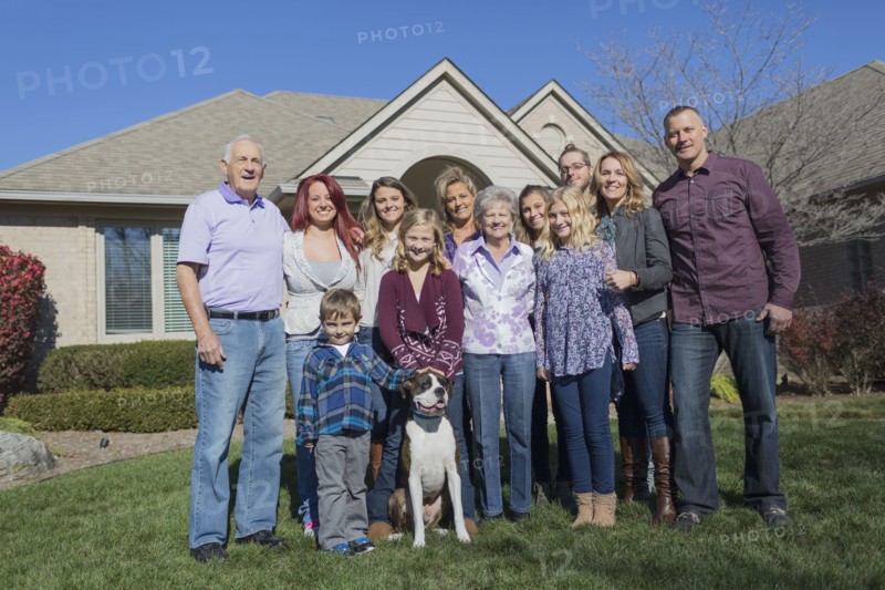 Caucasian multi-generation family smiling in yard