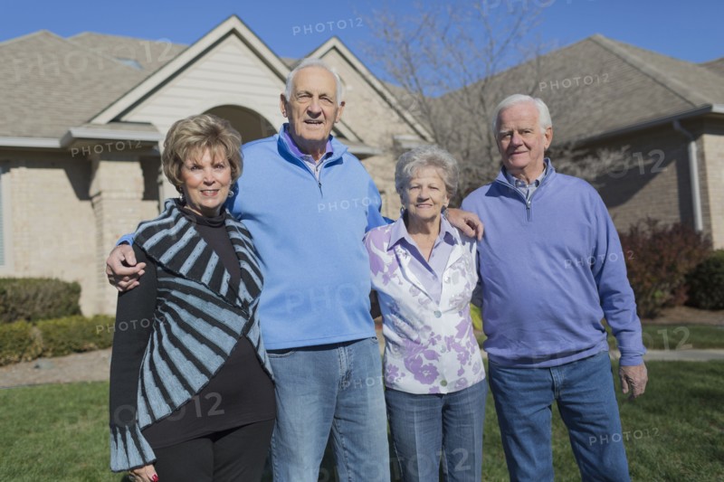 Older Caucasian friends smiling in yard