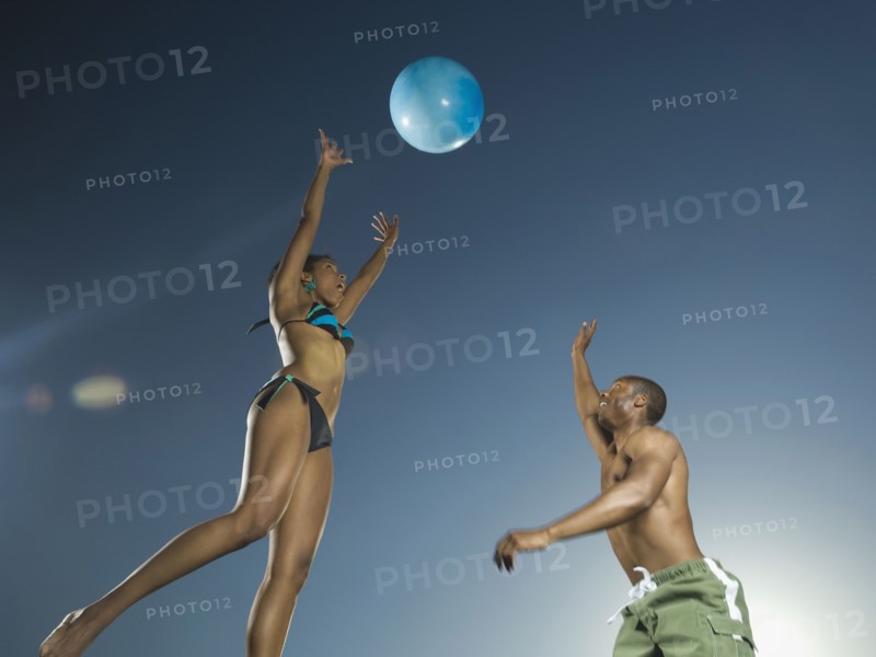 African American couple playing with beach ball