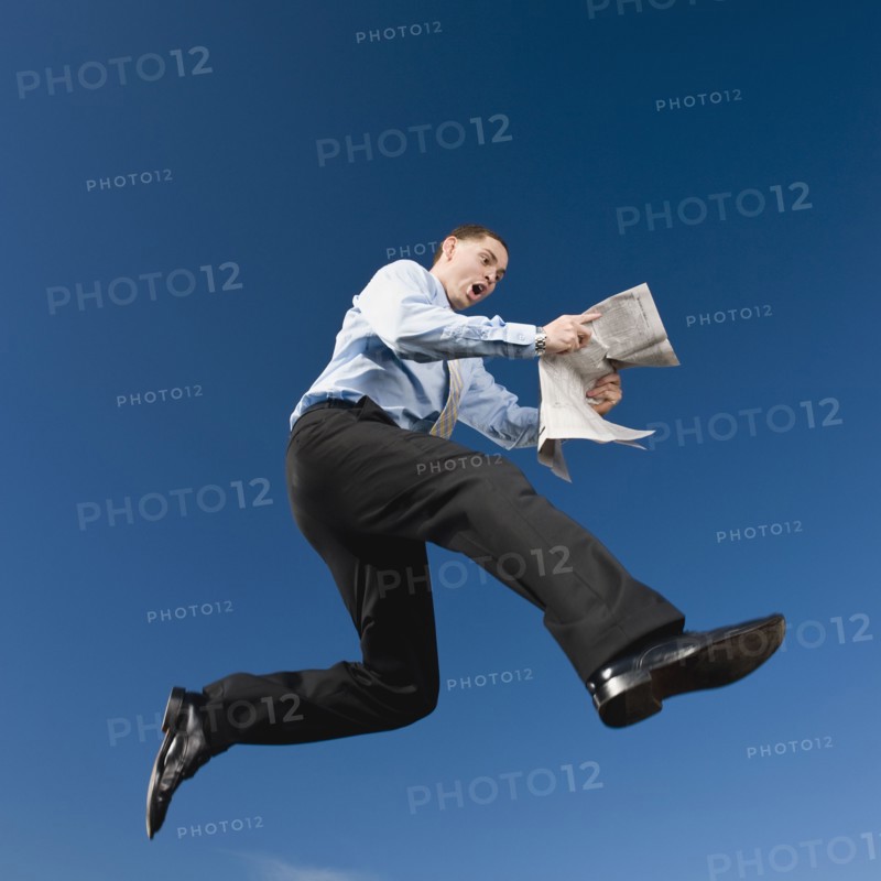 African businessman reading newspaper in mid-air