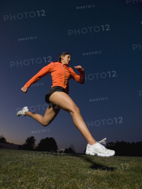Mixed race woman running on grass