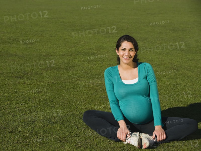 Pregnant Middle Eastern woman sitting in park