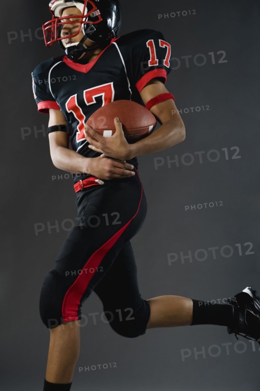 Mixed race football player holding football
