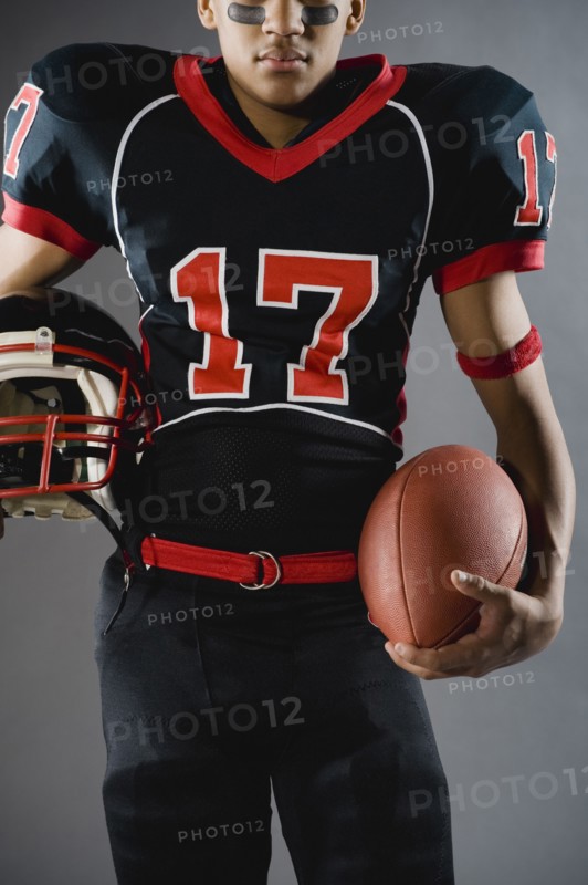 Mixed race football player holding football