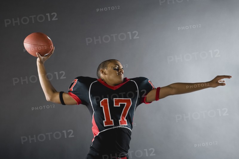 Mixed race quarterback throwing football