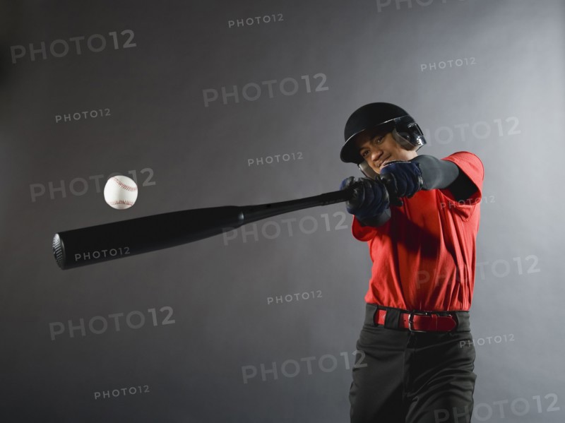 Mixed race baseball player swinging bat