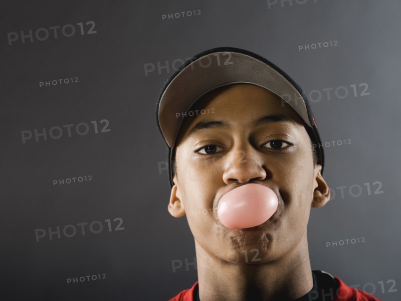 Mixed race baseball player blowing bubble with gum