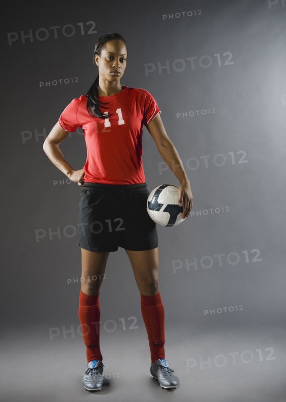 Mixed race soccer player holding soccer ball