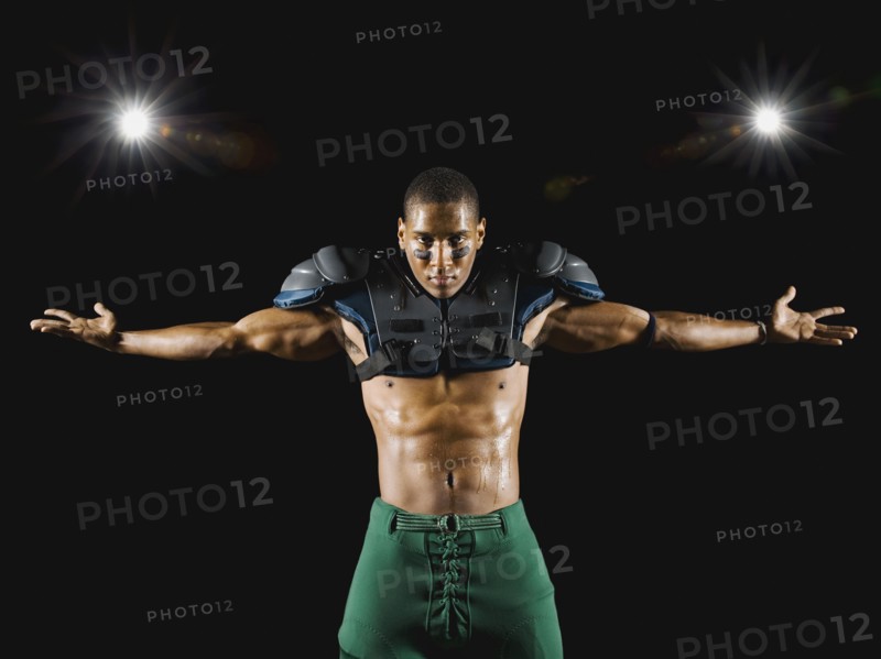 African football player wearing protective pads with arms outstretched