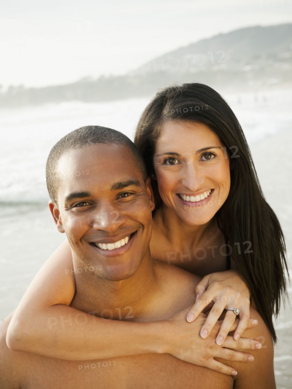 Smiling couple hugging on beach