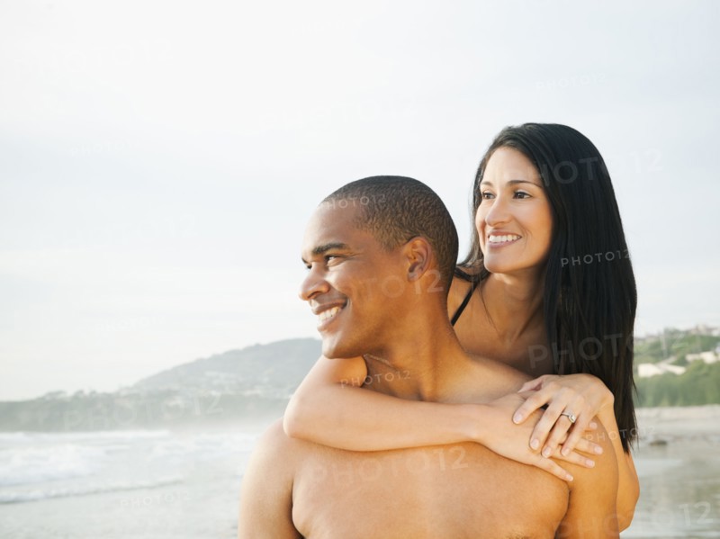 Smiling couple hugging on beach
