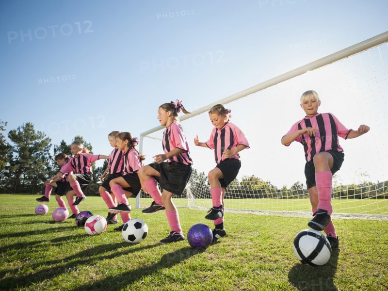 Girl soccer players practicing near net