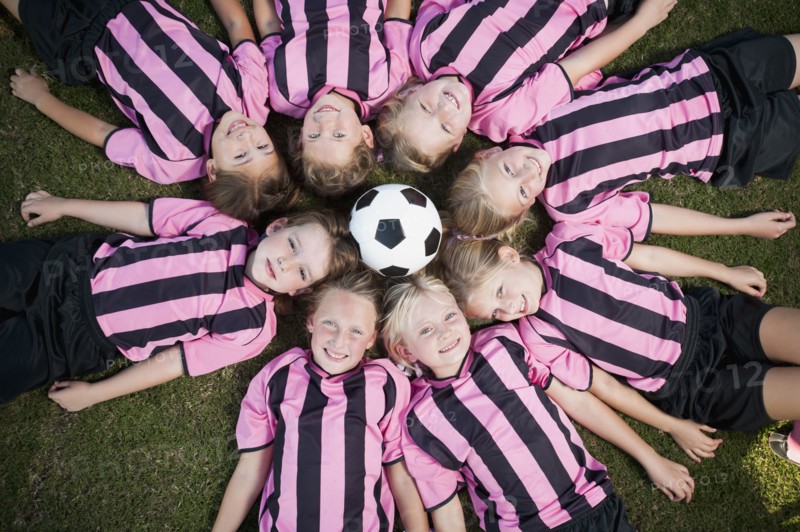 Girl soccer players laying in circle