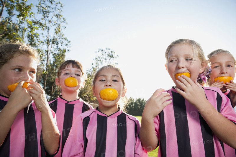 Girl soccer players eating orange slices