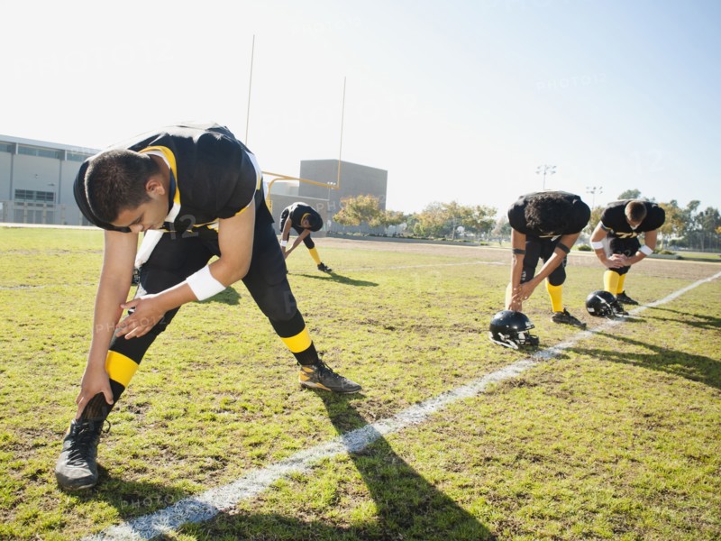 Football players stretching on football field